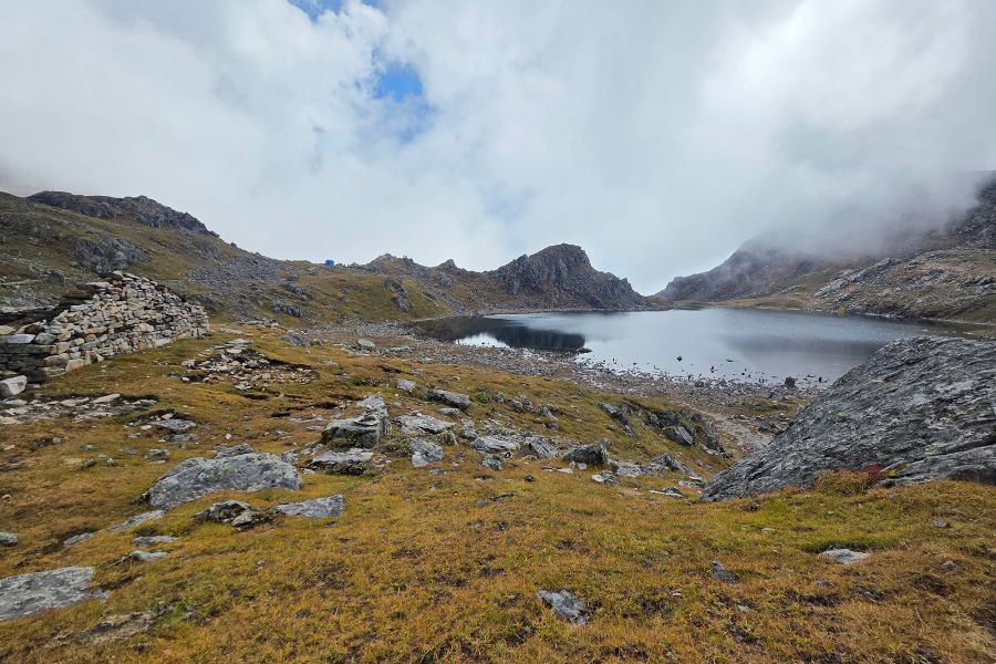 Misty alpine lake surrounded by rocky terrain in Gosaikunda region